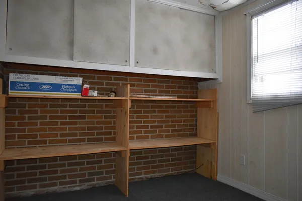 a view of a small space with wooden floor and a window