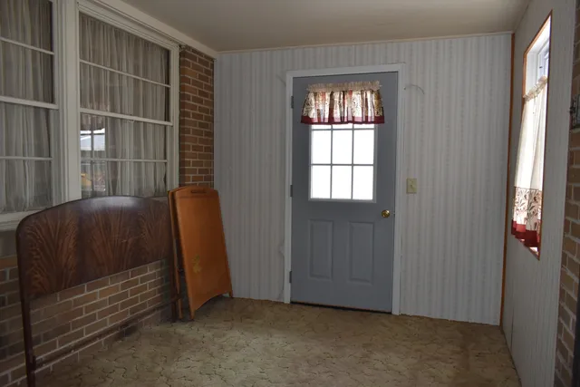 a view of a small space with wooden floor and a window