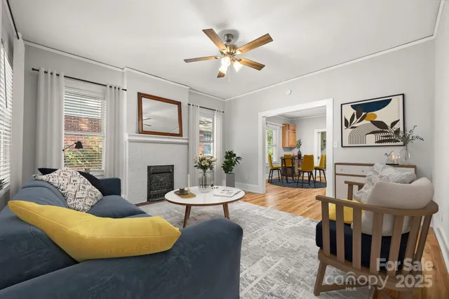 a living room with furniture a fireplace and a window