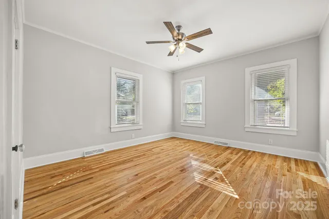 a view of empty room with wooden floor and window