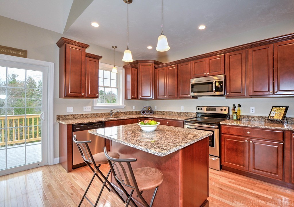 54 Partridge Hill Road Sutton, MA 01590 - Photo 5 of 20 a kitchen with a stove a sink a center island and a window