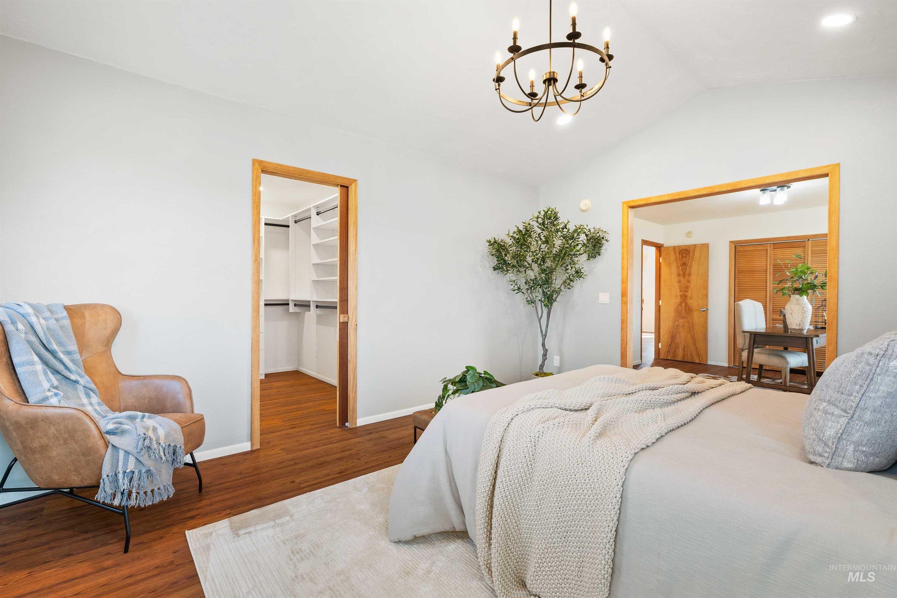 853 Pottery Road Bliss, ID 83314 - Photo 16 of 50 Bedroom with lofted ceiling, wood finished floors, a walk in closet, and a chandelier