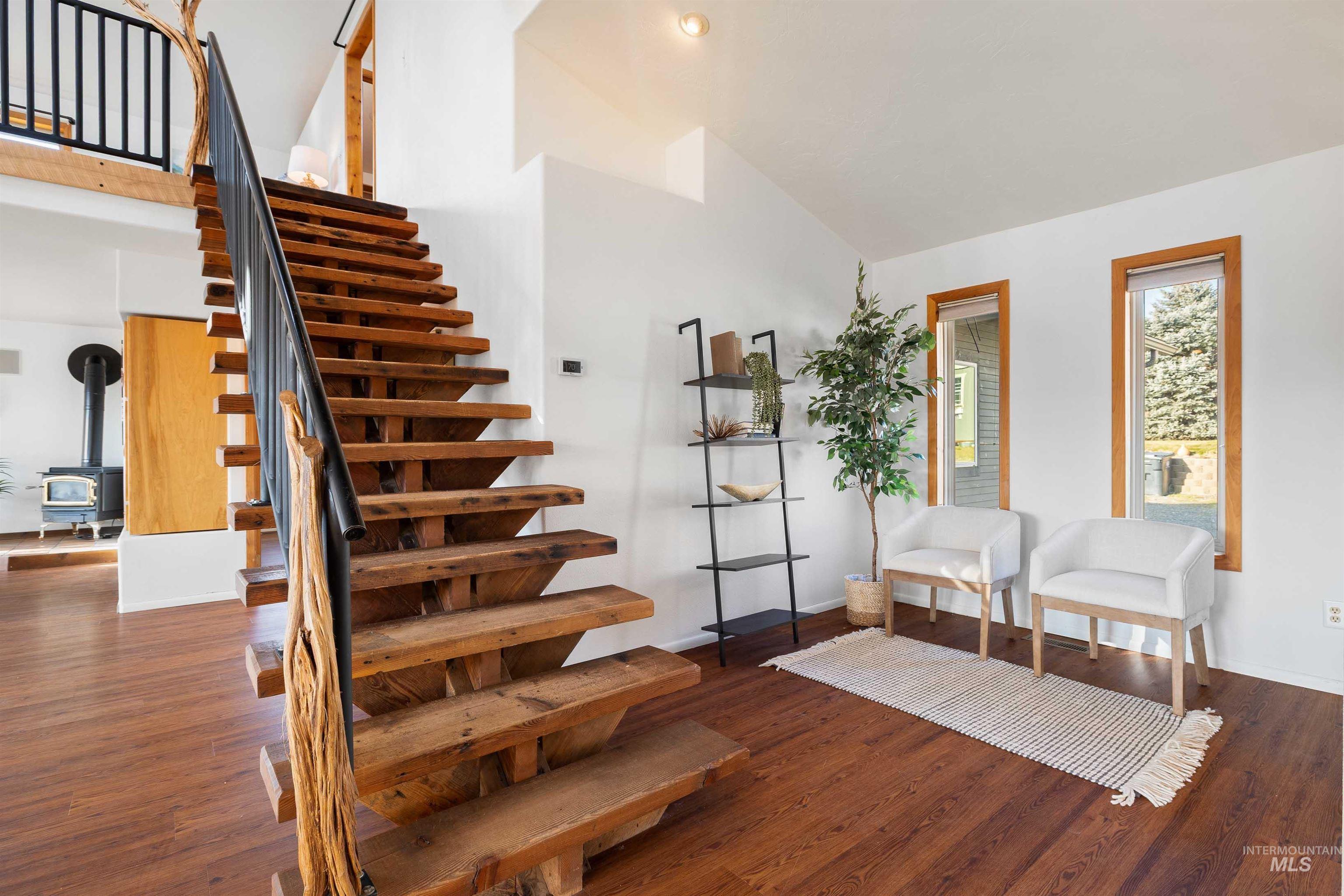853 Pottery Road Bliss, ID 83314 - Photo 21 of 50 Stairs with a wood stove, wood finished floors, and a towering ceiling