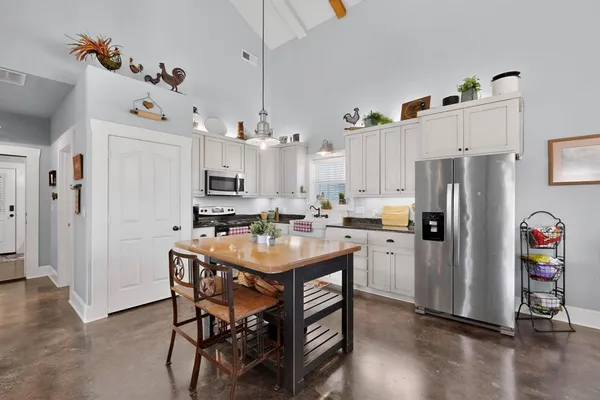 a kitchen with granite countertop white cabinets and stainless steel appliances
