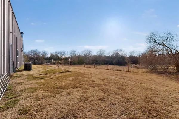 a view of road and house with trees in the background