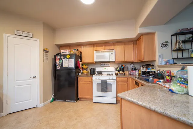 a kitchen with stainless steel appliances granite countertop a refrigerator and a sink