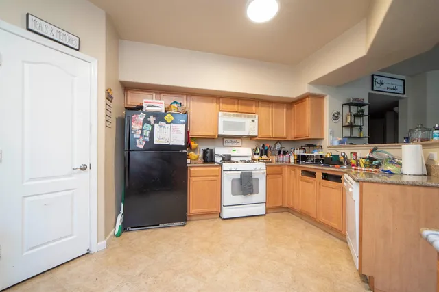 a kitchen with stainless steel appliances granite countertop a refrigerator and a stove top oven