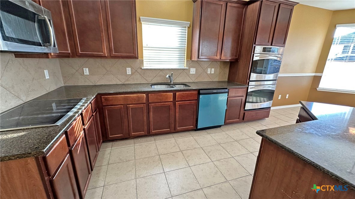 5203 Willamette Lane Killeen, TX 76549 - Photo 15 of 48 a kitchen with stainless steel appliances granite countertop a sink a stove microwave and cabinets