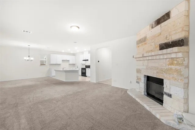 a view of an empty room with a fireplace and a window