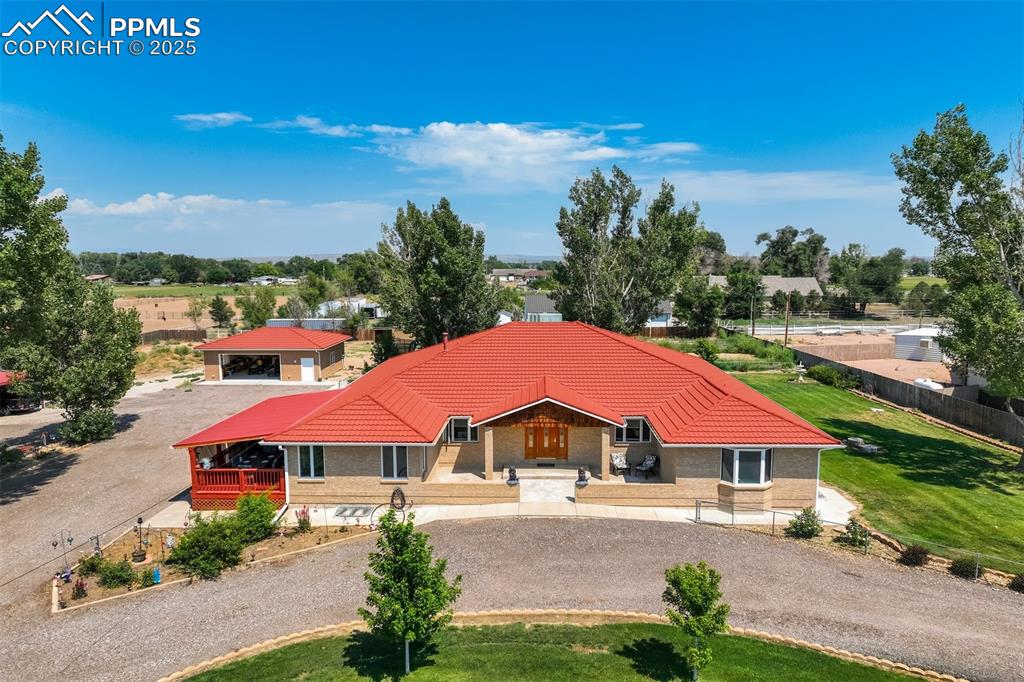 View of front of property featuring curved driveway, a Decra metal tile roof, and covered porch