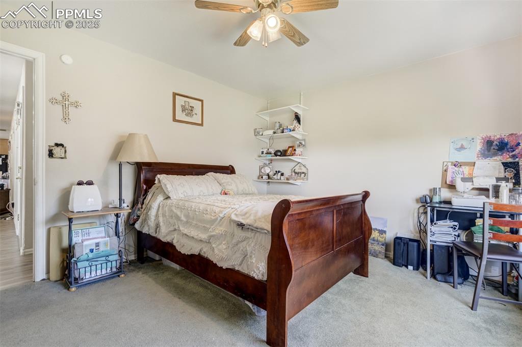 27875 County Farm Road Pueblo, CO 81006 - Photo 21 of 50 a bedroom with a bed and a chandelier