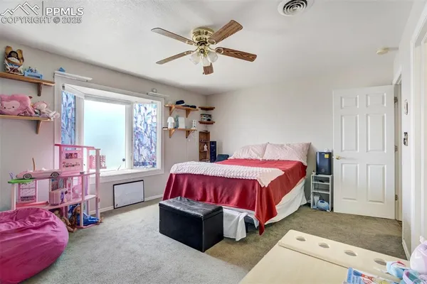 a spacious bedroom with a bed and a chandelier
