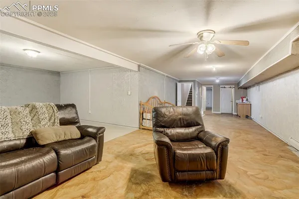 a living room with furniture and a ceiling fan