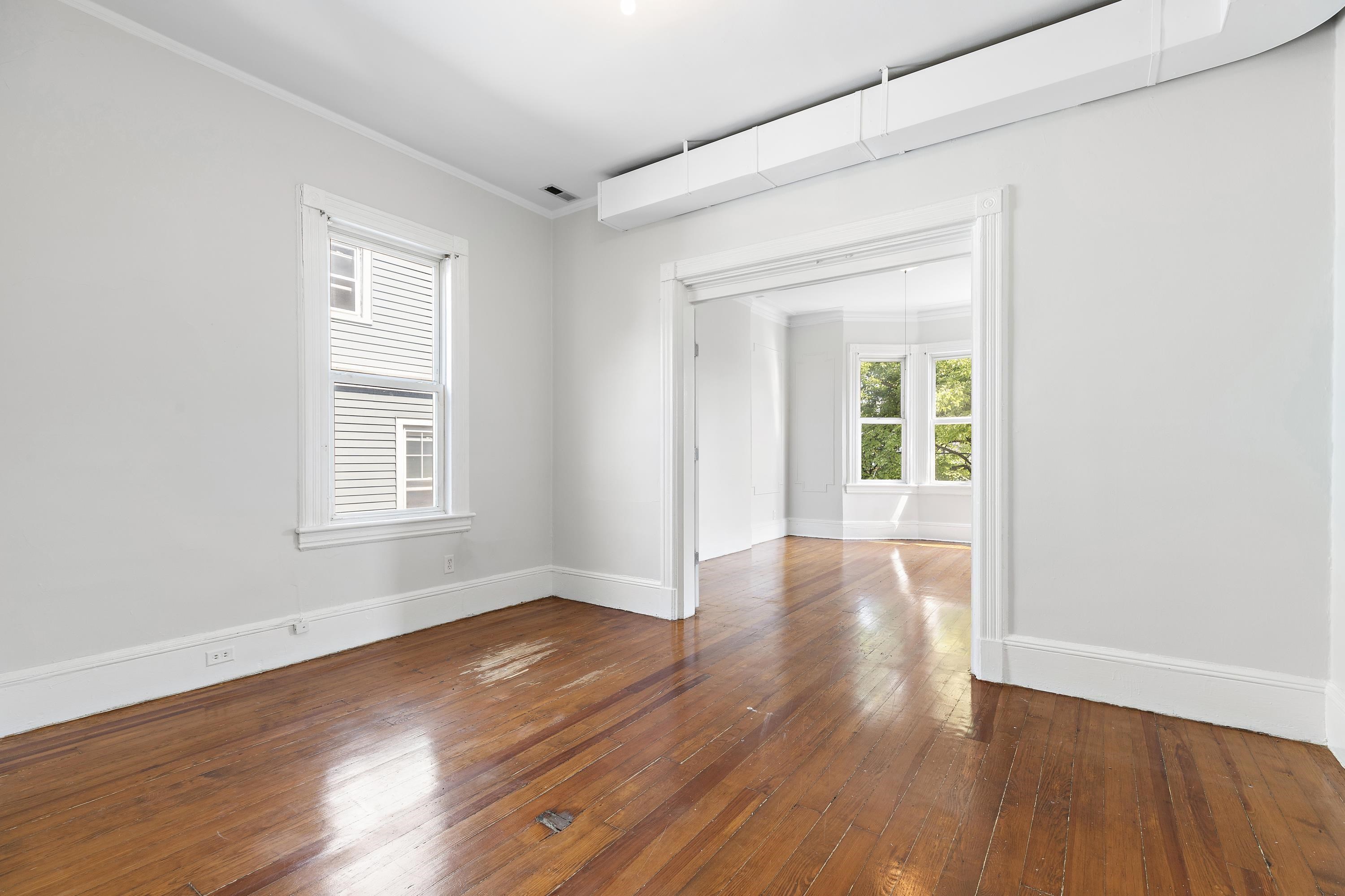11 Hudson Place, Unit 2 Weehawken, NJ 07086 - Photo 4 of 16 an empty room with wooden floor and windows