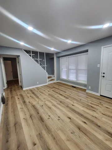 a view of empty room with wooden floor