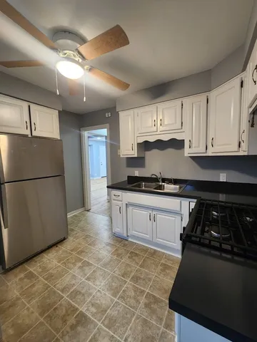 a kitchen with granite countertop a stove and a refrigerator