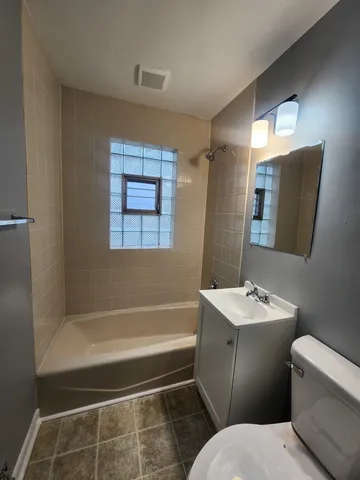 a bathroom with a sink a toilet a mirror a vanity and bathtub