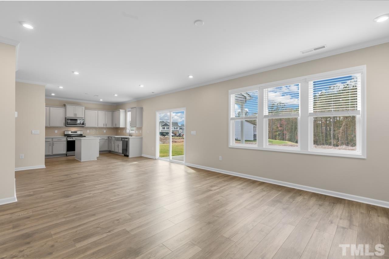 47 Madden Rose Loop Garner, NC 27529 - Photo 13 of 31 a view of an empty room with wooden floor and a window