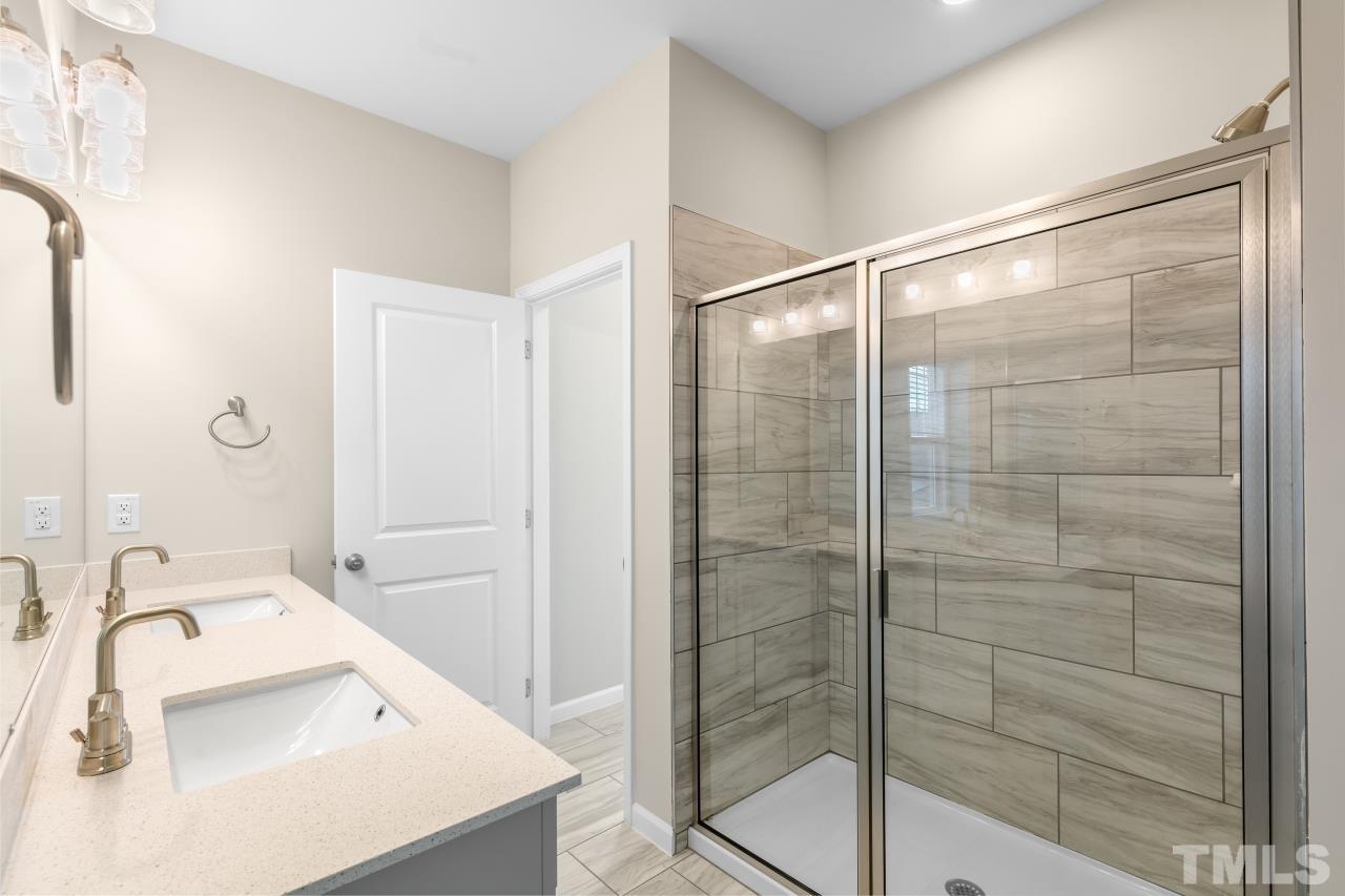 47 Madden Rose Loop Garner, NC 27529 - Photo 23 of 31 a bathroom with a shower sink and mirror