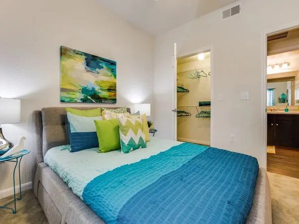 a bedroom with a bed and painting on the wall