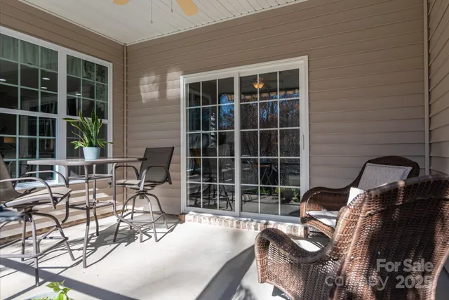 a view of a white house with a big yard and potted plants