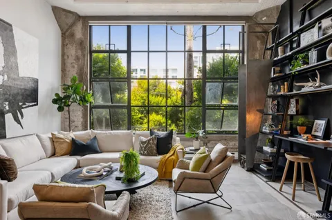 a living room with furniture a bookshelf and a large window