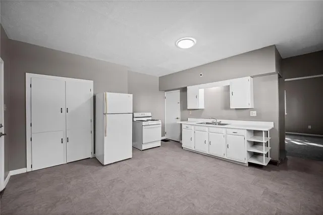 a kitchen with white cabinets and white appliances