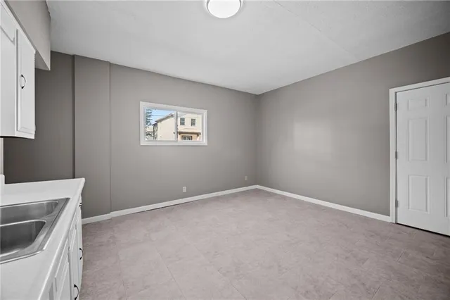 a view of an empty room with a window and washer