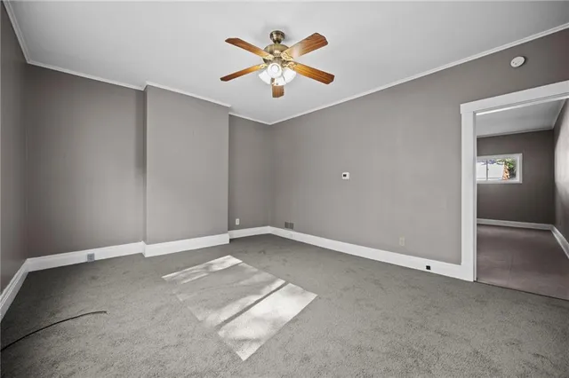 an empty room with closet and fan