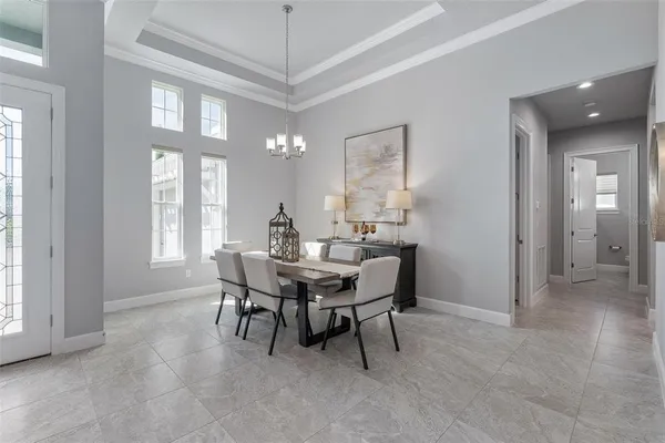a view of a dining room with furniture and a chandelier