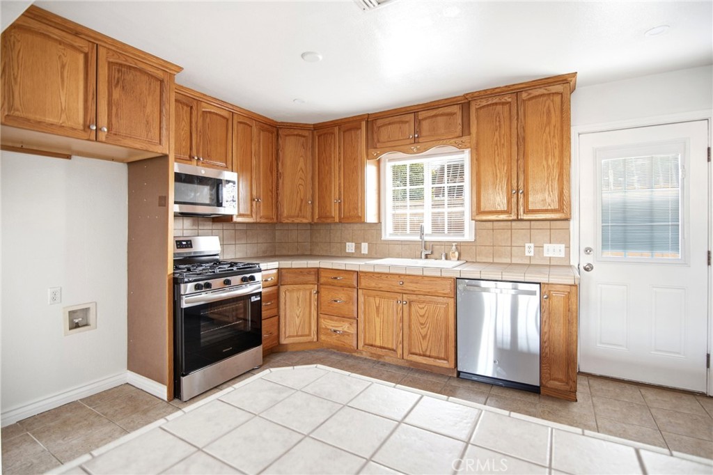 11296 Lampson Avenue Garden Grove, CA 92840 - Photo 8 of 18 a kitchen with stainless steel appliances granite countertop a stove top oven a sink and dishwasher
