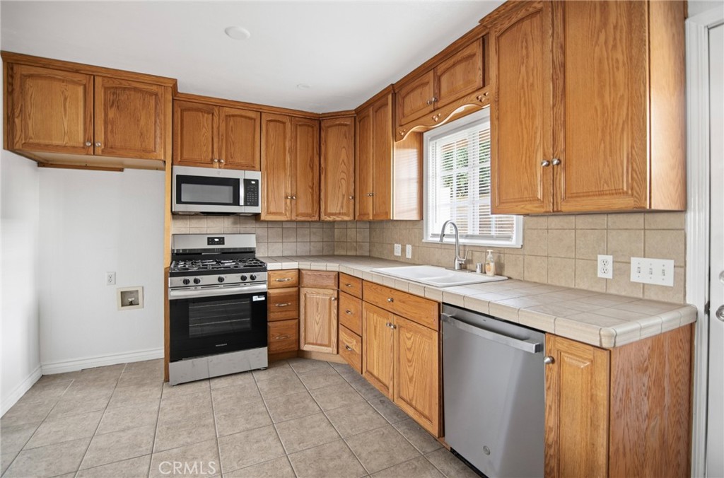 11296 Lampson Avenue Garden Grove, CA 92840 - Photo 9 of 18 a kitchen with stainless steel appliances granite countertop a stove a sink and a microwave