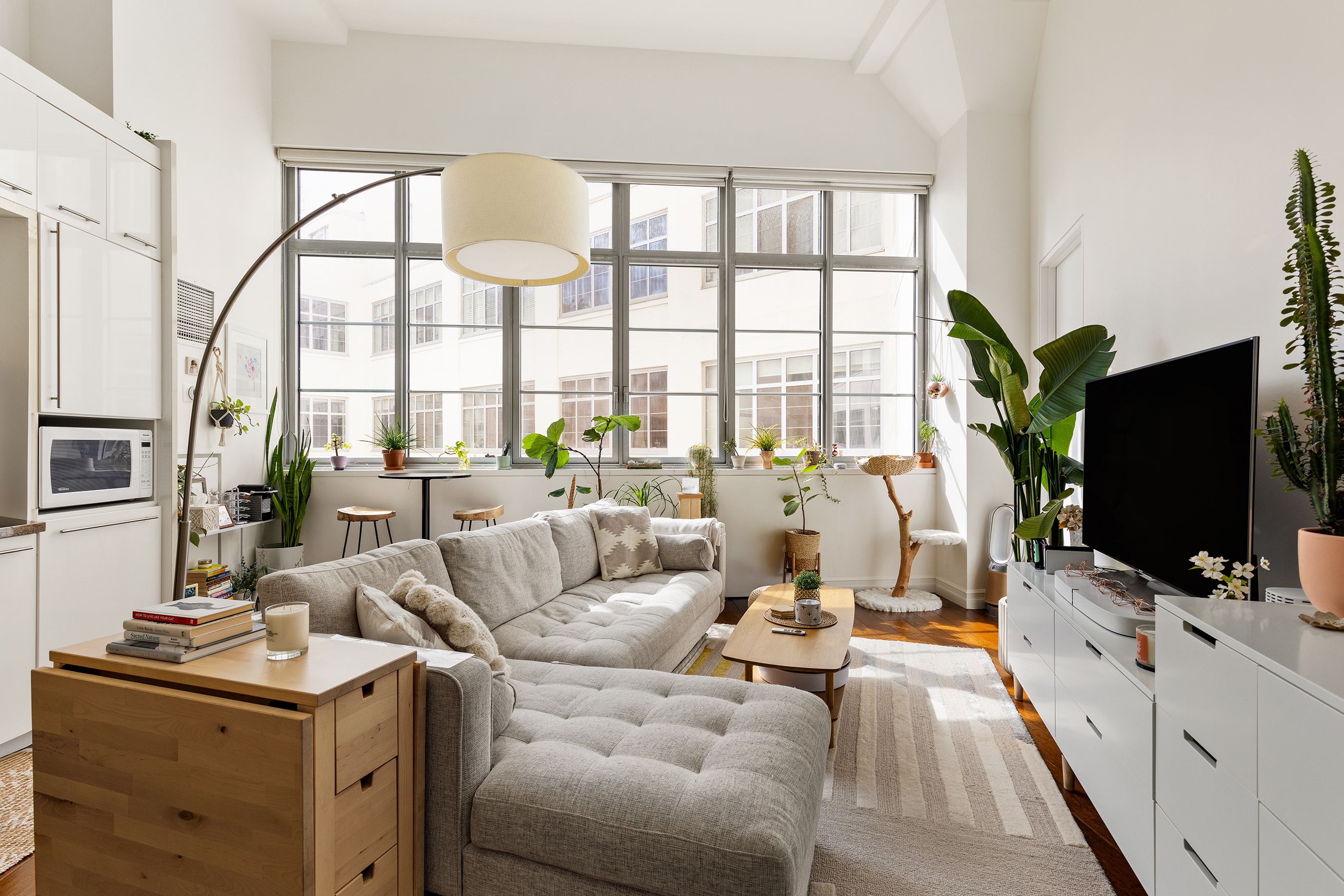 27-28 Thomson Avenue, Unit 453 Queens, NY 11101 - Photo 1 of 1 a living room with furniture a flat screen tv and a large window