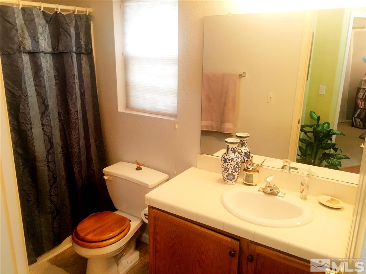 9741 South Legacy Court Reno, NV 89521 - Photo 14 of 19 a bathroom with a sink a toilet and a mirror