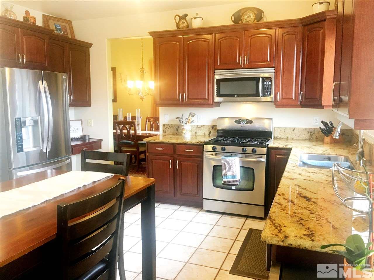 9741 South Legacy Court Reno, NV 89521 - Photo 5 of 19 a kitchen with stainless steel appliances granite countertop a stove a sink and a microwave