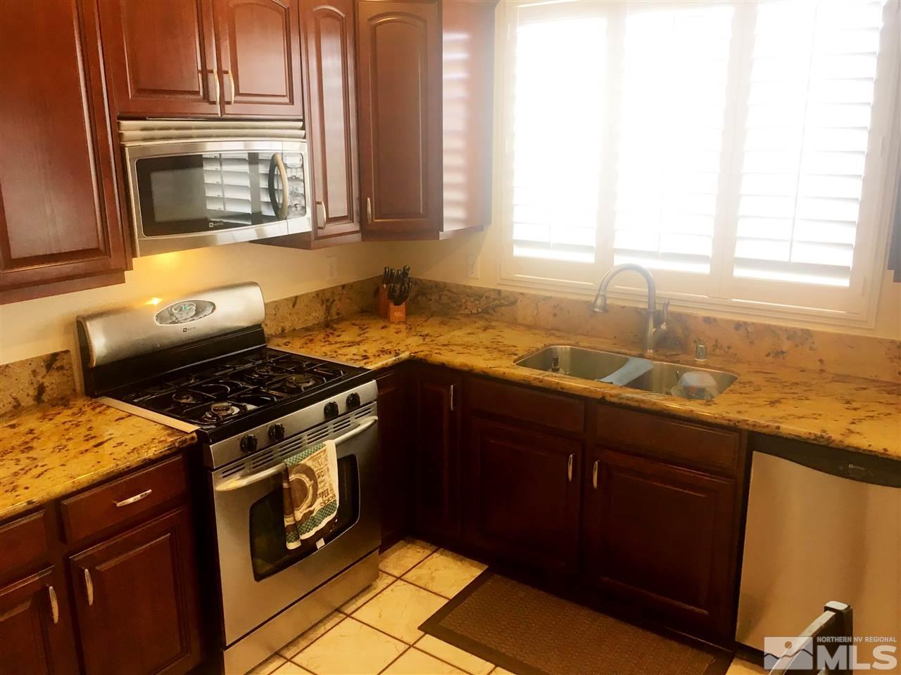 9741 South Legacy Court Reno, NV 89521 - Photo 6 of 19 a kitchen with granite countertop a stove sink and cabinets
