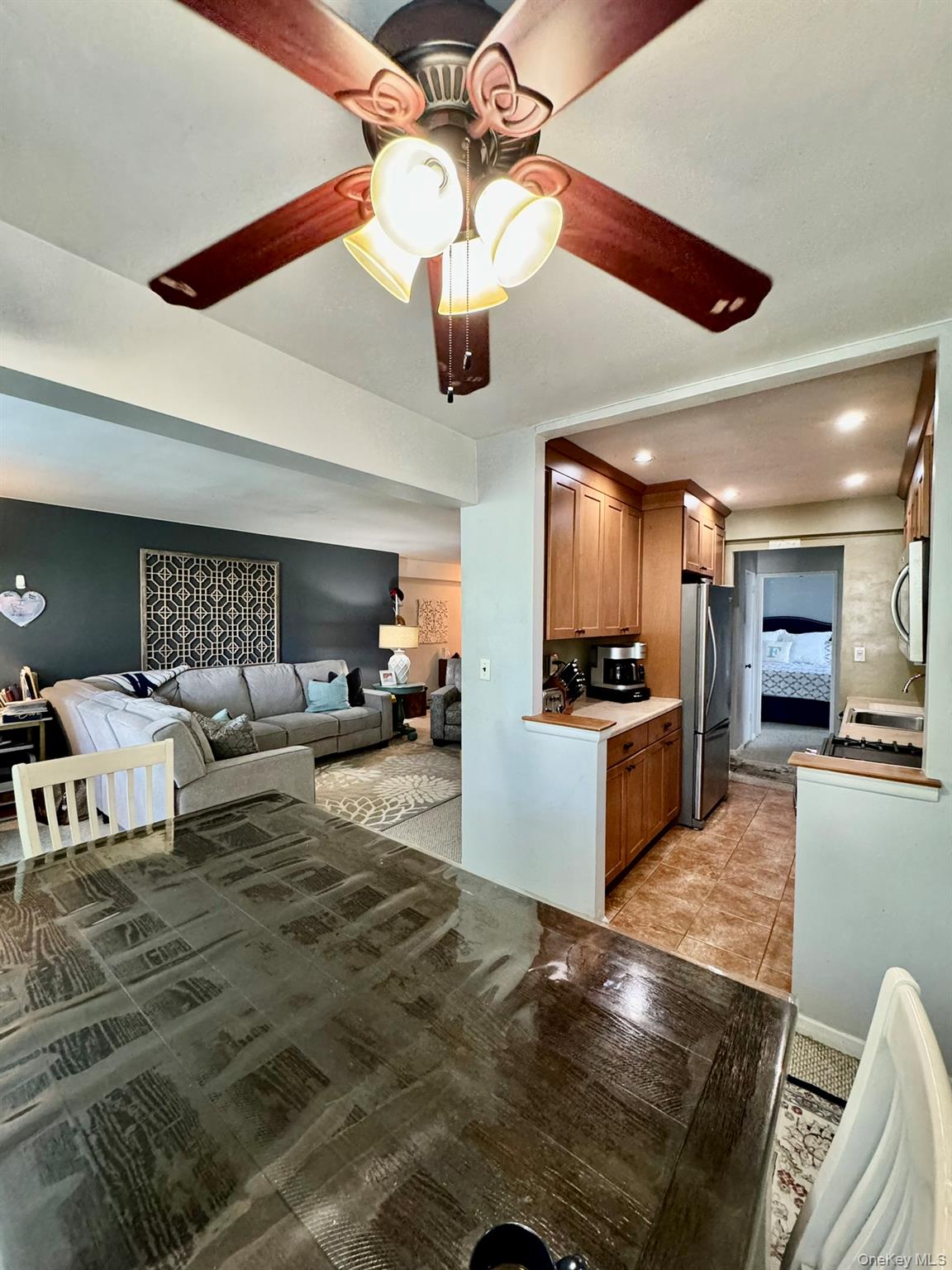 245 Rumsey Road, Unit 6D Yonkers, NY 10701 - Photo 10 of 10 Kitchen with brown cabinets, light countertops, open floor plan, a ceiling fan, and appliances with stainless steel finishes