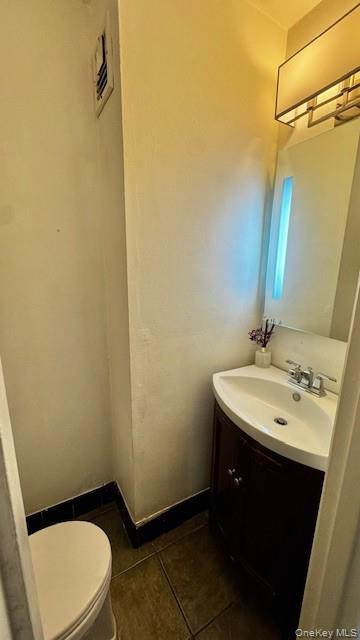 245 Rumsey Road, Unit 6D Yonkers, NY 10701 - Photo 7 of 10 Half bathroom with vanity and dark tile patterned flooring