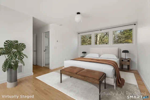 a bedroom with a bed and large windows