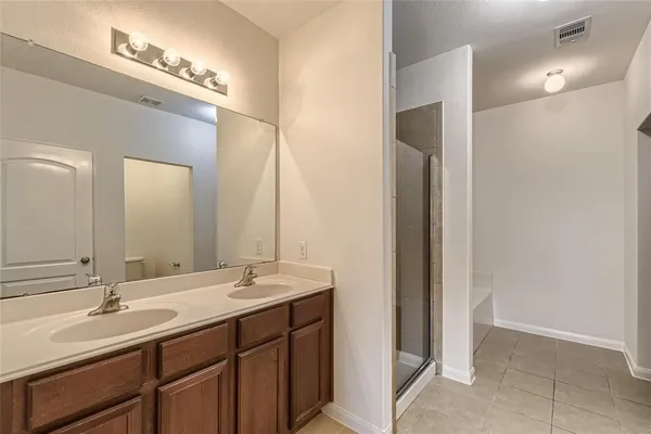 a bathroom with a double vanity sink and a mirror