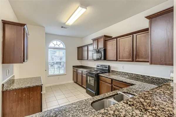 a kitchen with stainless steel appliances granite countertop a stove a sink and a refrigerator