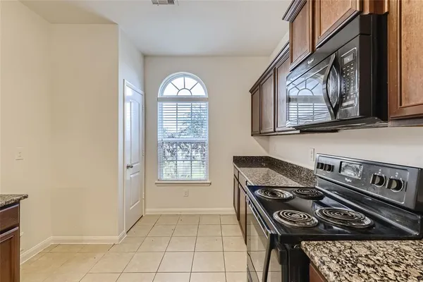 a kitchen with stainless steel appliances granite countertop a stove a sink and a microwave