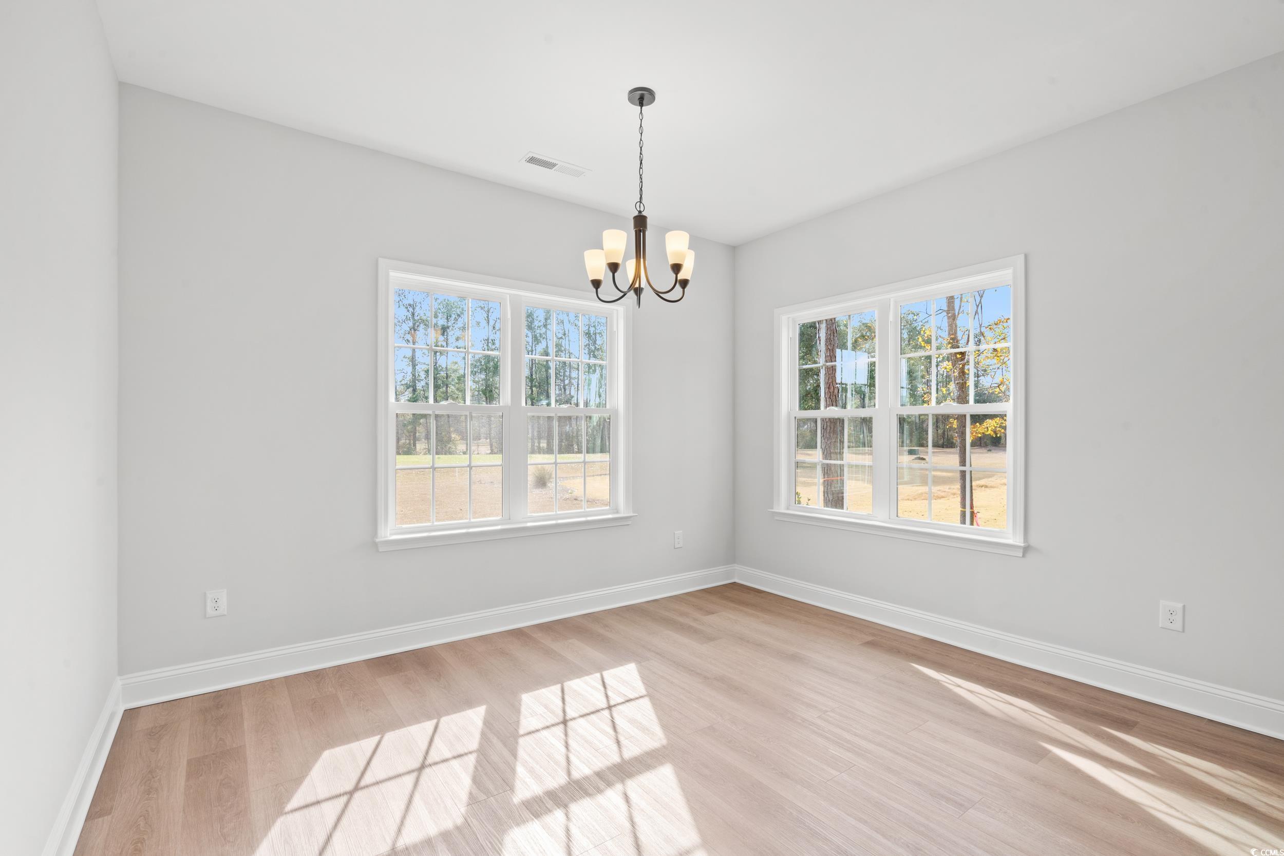 908 Francis Parker Road Georgetown, SC 29440 - Photo 8 of 37 Spare room with light wood-style flooring and a chandelier