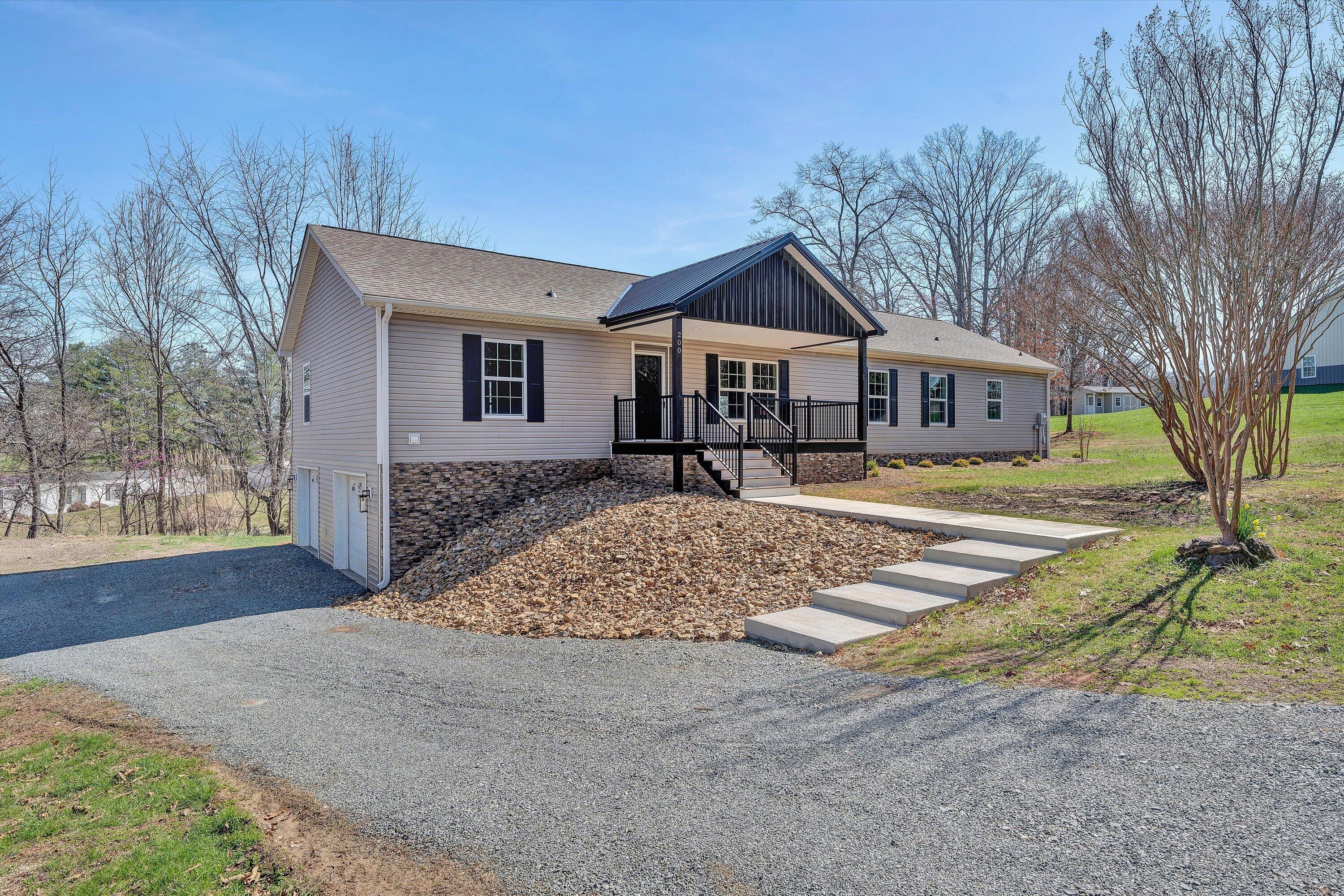 200 Surber Drive Moneta, VA 24121 - Photo 3 of 52 a front view of a house with a yard and garage