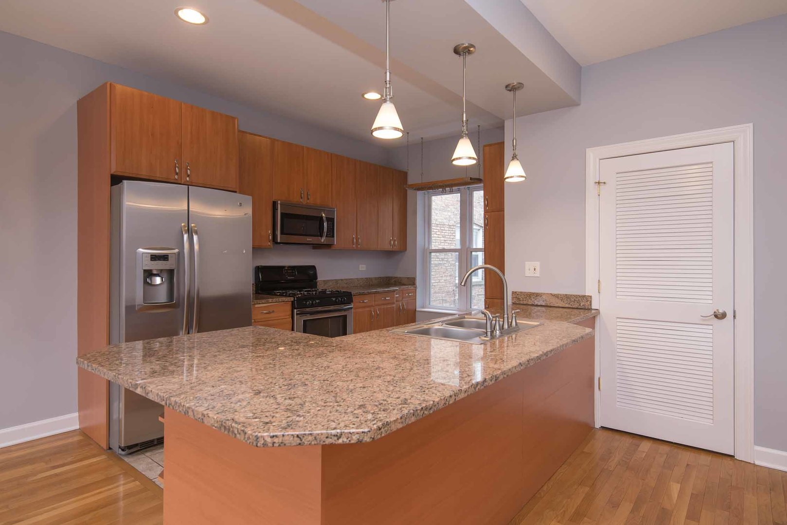 1628 West Juneway Terrace, Unit 2W Chicago, IL 60626 - Photo 11 of 23 a kitchen with kitchen island a counter top space appliances and a center island