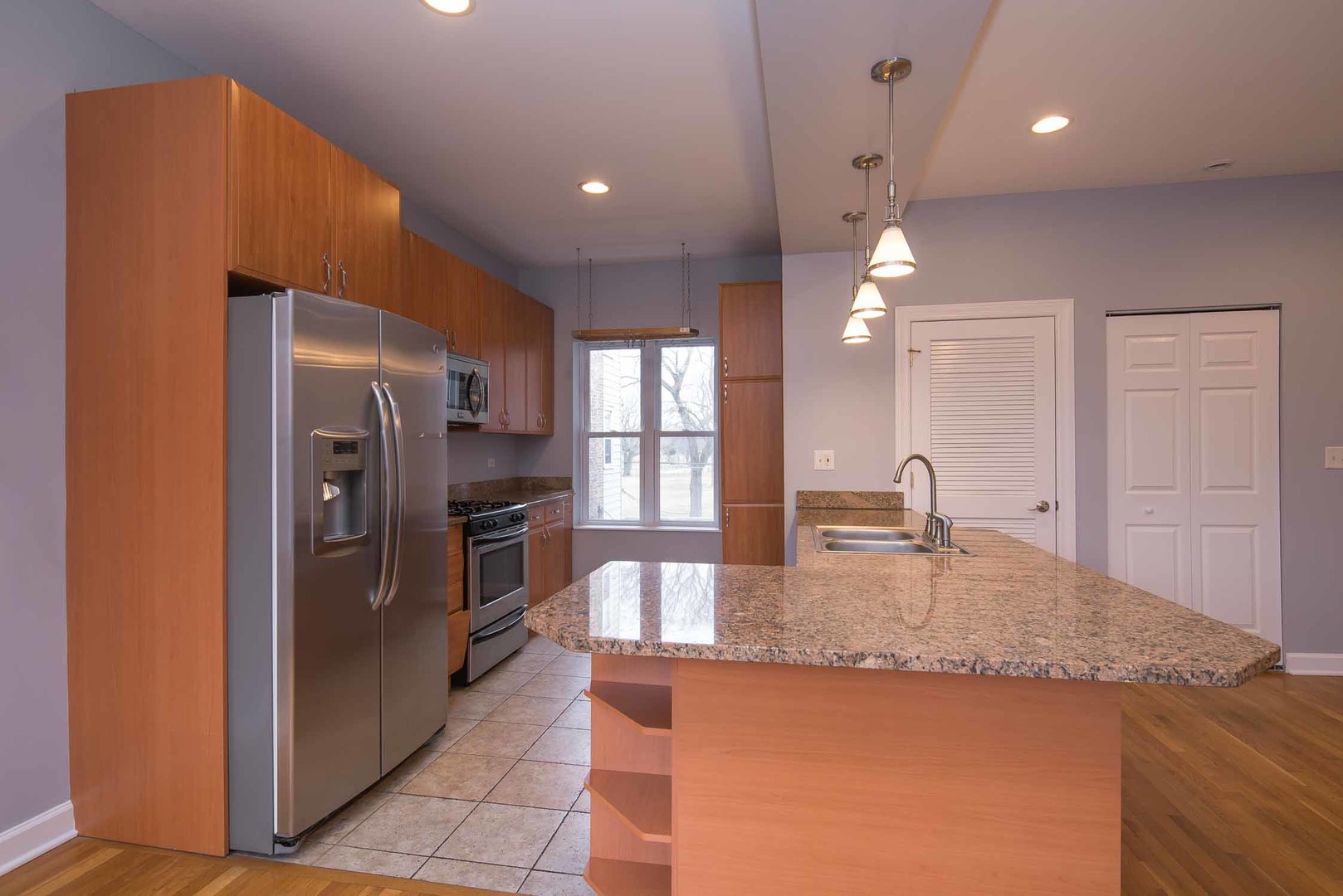 1628 West Juneway Terrace, Unit 2W Chicago, IL 60626 - Photo 12 of 23 a kitchen with granite countertop kitchen island a sink appliances and cabinets