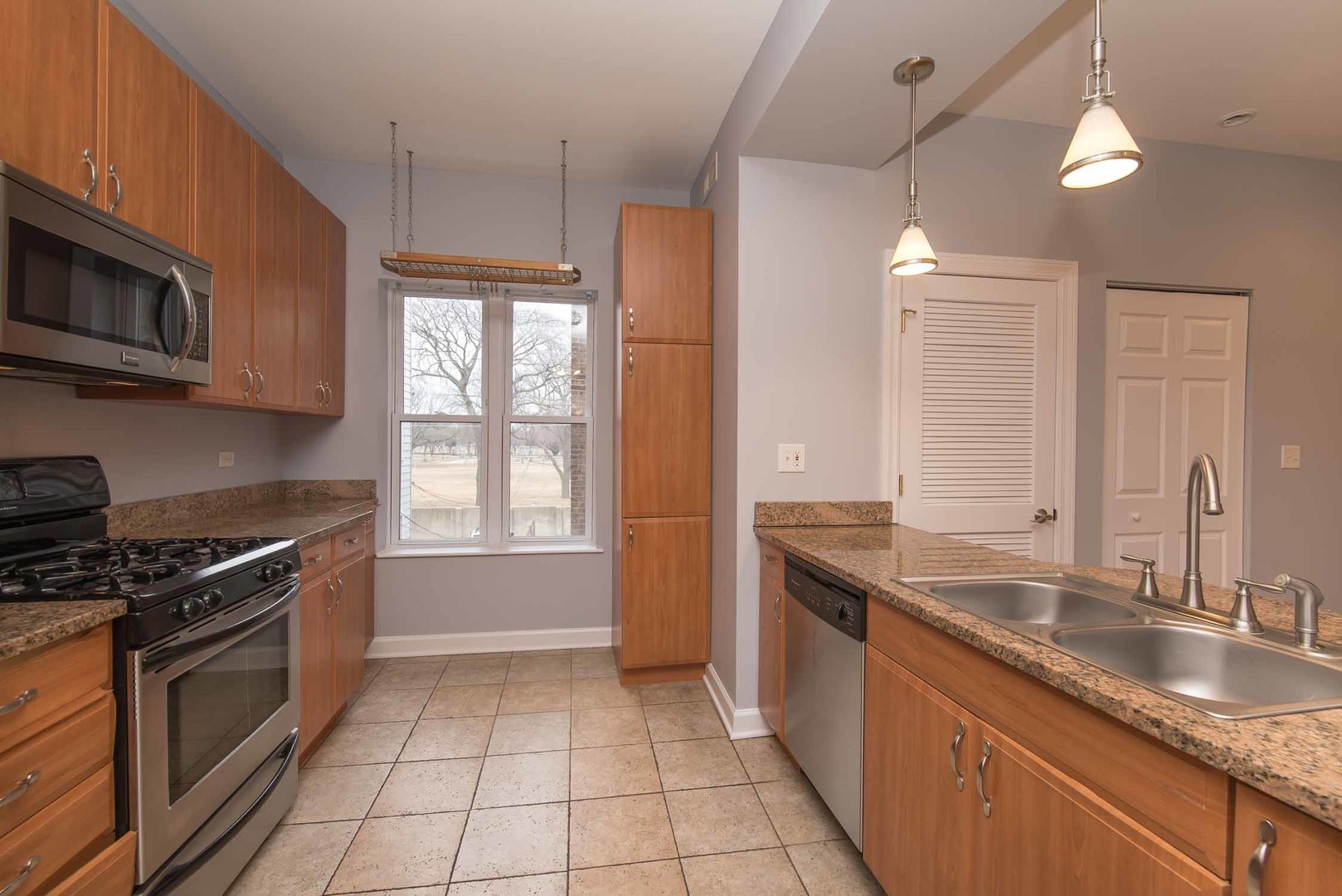 1628 West Juneway Terrace, Unit 2W Chicago, IL 60626 - Photo 13 of 23 a kitchen with granite countertop a sink stainless steel appliances and cabinets