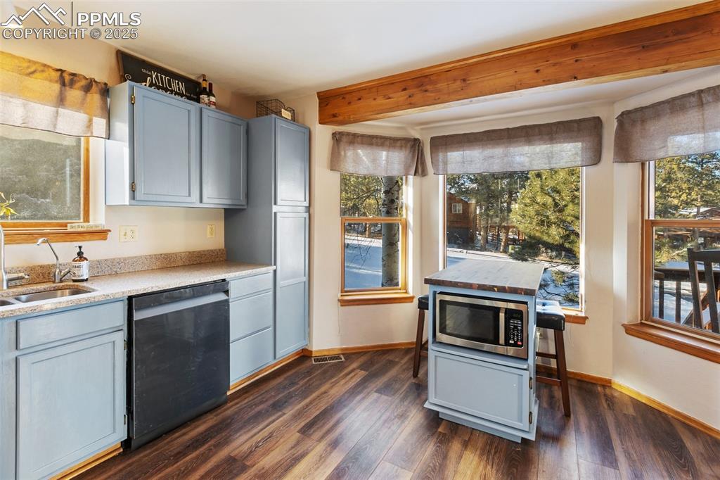 747 Pinon Ridge Drive Woodland Park, CO 80863 - Photo 7 of 32 a kitchen with granite countertop a stove a sink and wooden floors