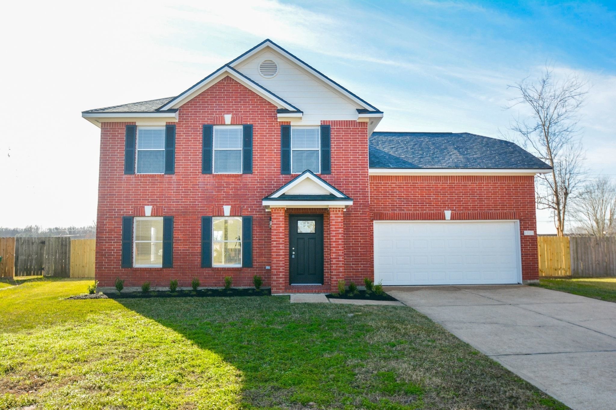 a front view of a house with a garden and yard
