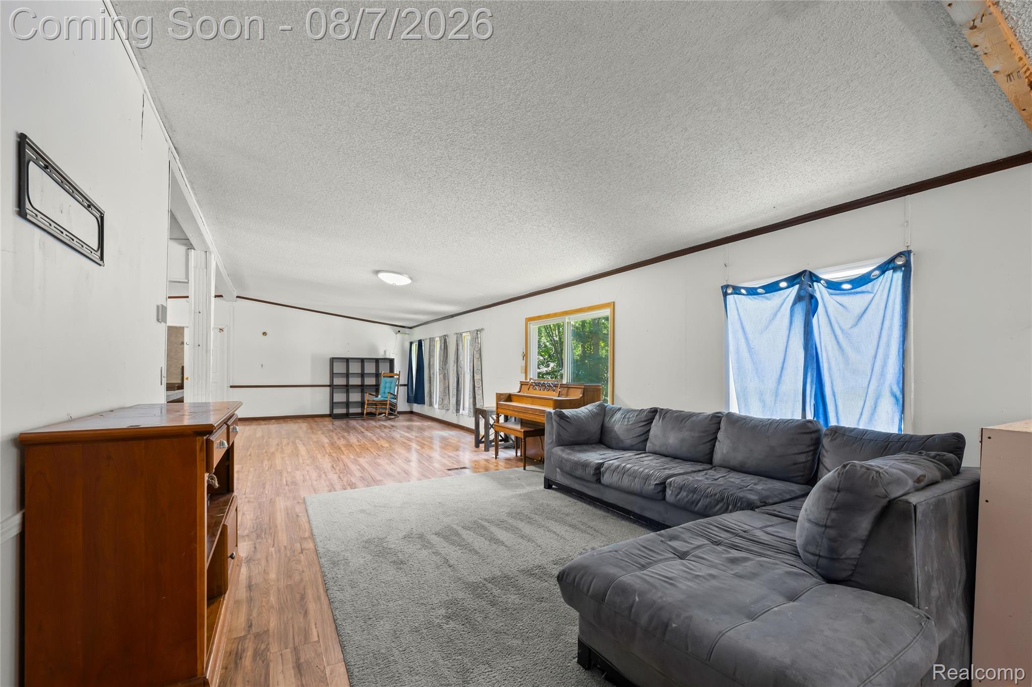 9940 Bunton Road Willis, MI 48191 - Photo 15 of 26 Spacious open-concept living area featuring wood-finish flooring, recessed ceiling lighting, and abundant natural light from multiple windows